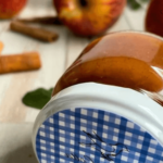 Homemade strawberry apple sauce in a jar, garnished with fresh fruits on a rustic kitchen table