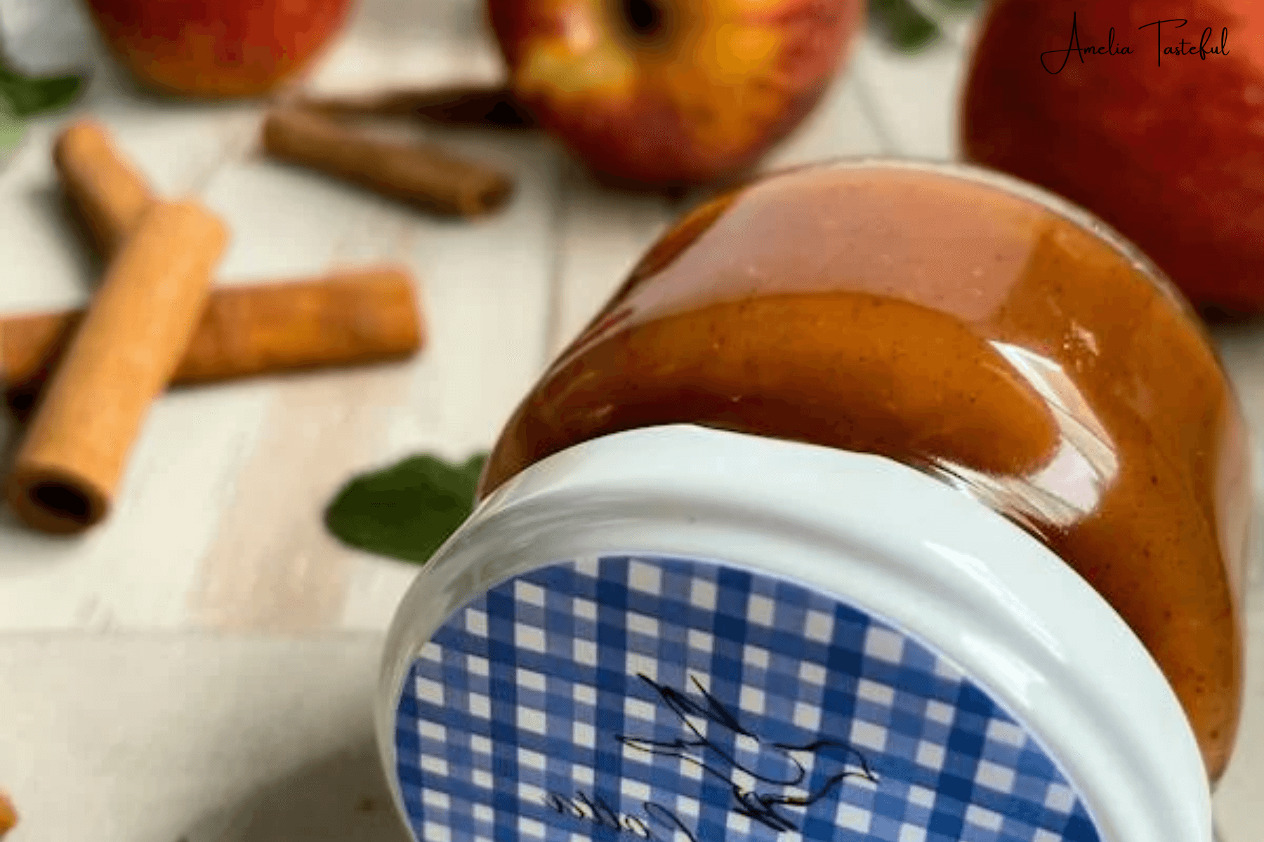 Homemade strawberry apple sauce in a jar, garnished with fresh fruits on a rustic kitchen table